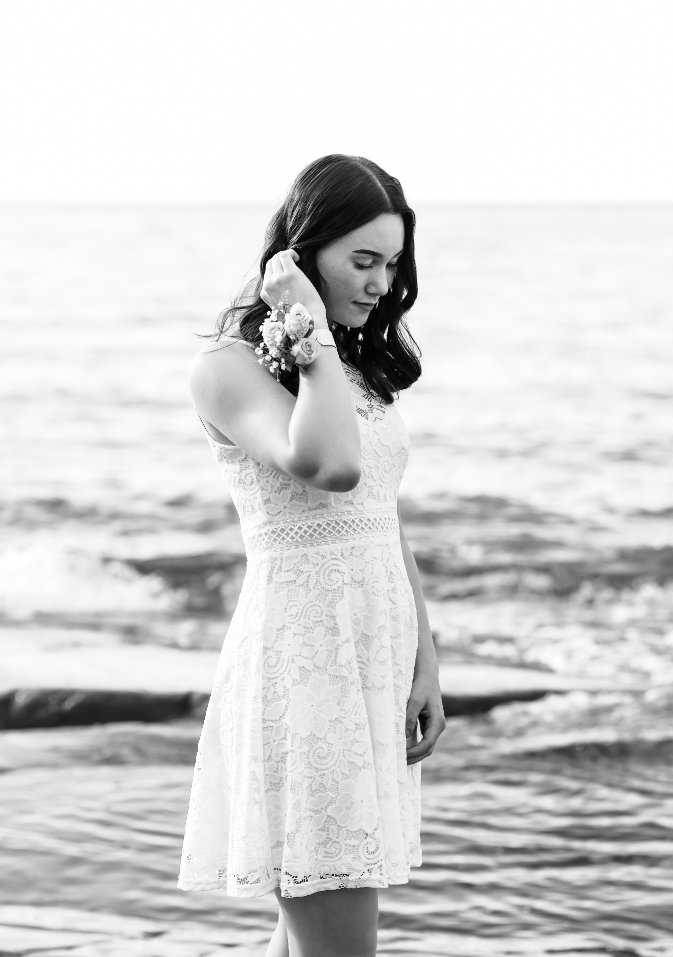 Young woman in white lace dress by the sea