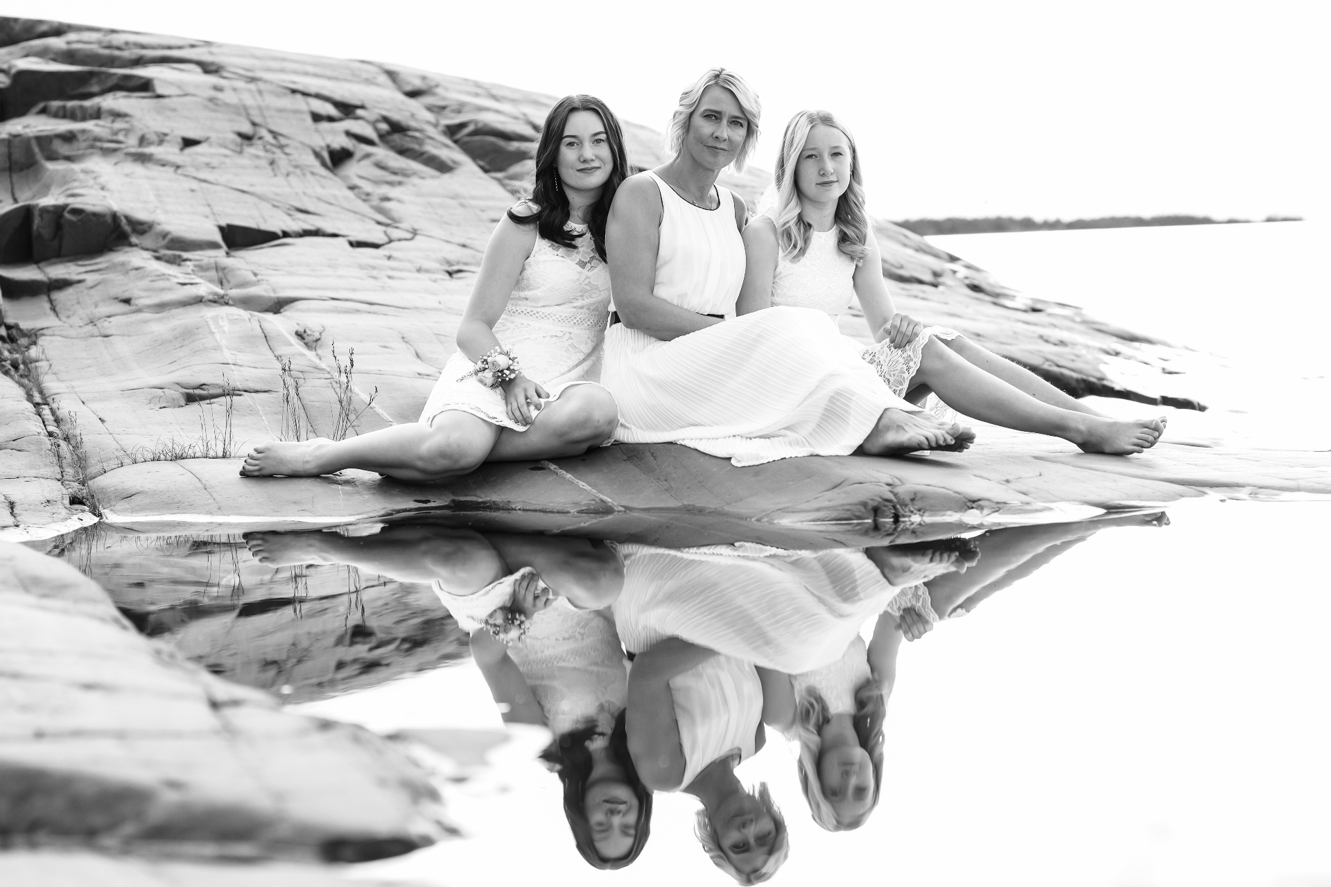 Mother and daughters reflected on lakeside rocks