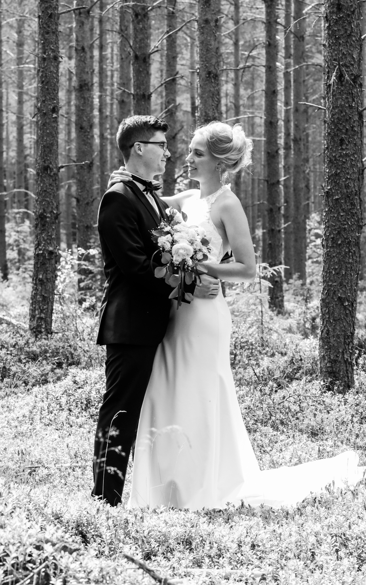 Bride and groom embracing in a pine forest