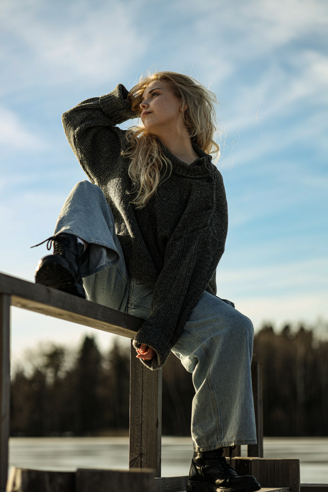 Young woman on a lakeside dock in golden light