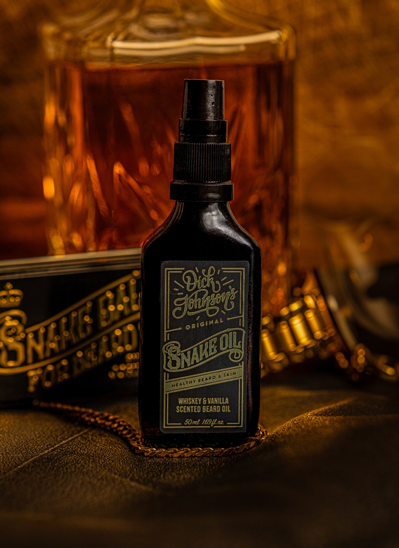 Beard oil bottle in warm amber light with whiskey decanter